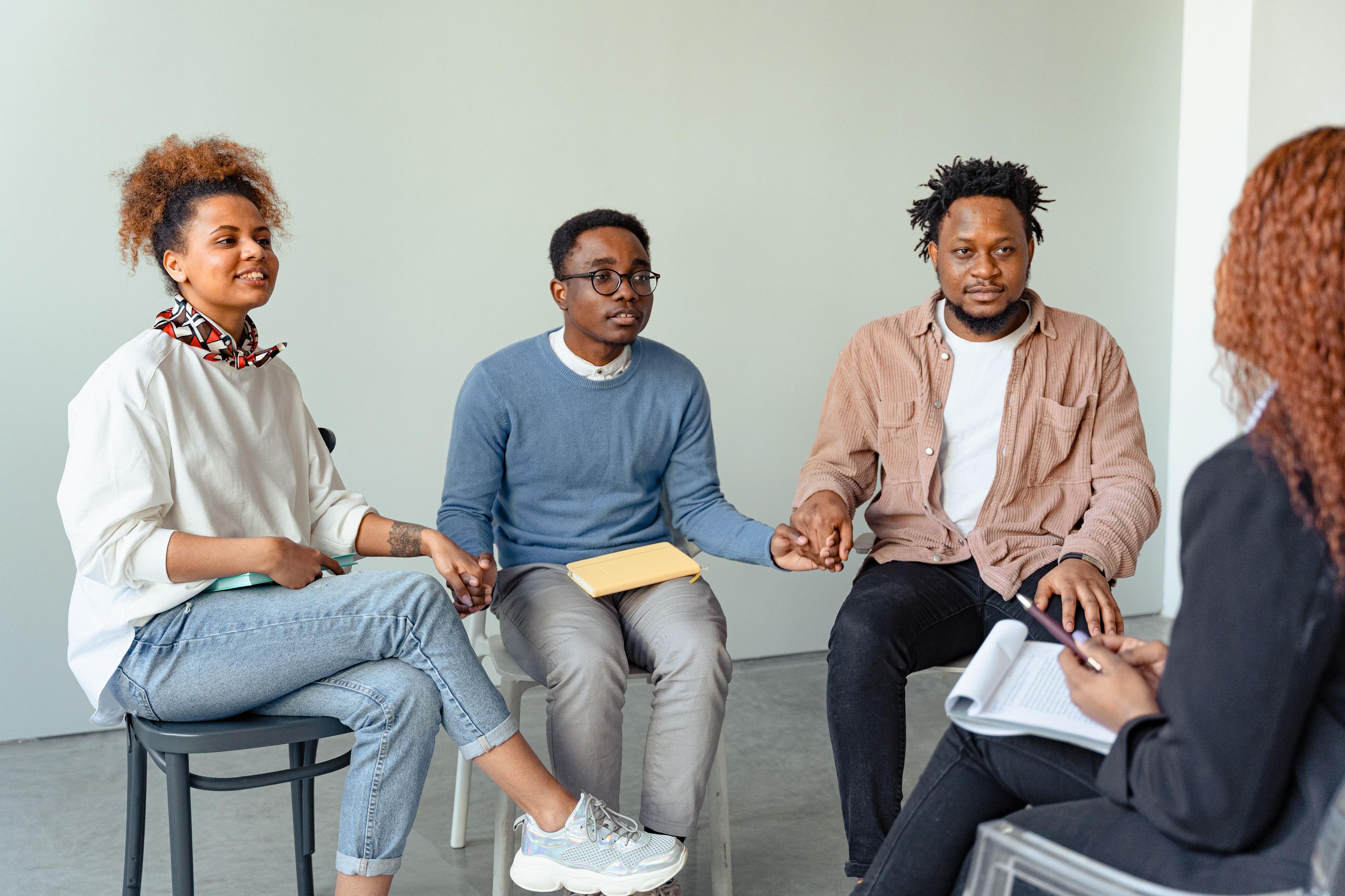A group therapy session in progress, four people seated in conversation